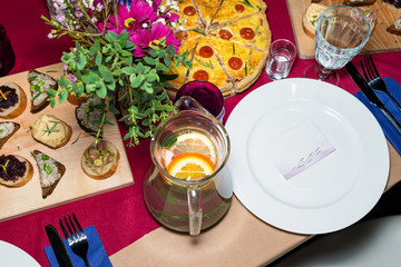 Decorated table ready for dinner. Beautifully decorated table set with flowers, candles, plates and serviettes for wedding or another event in the restaurant.