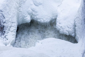 Icicles and snow near flowing water