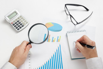 Businessman counting losses and profit working with statistics, analyzing financial the results on white background. Copy space