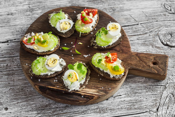 Sandwiches with soft cheese, quail eggs, cherry tomatoes and celery. Delicious healthy snack or breakfast