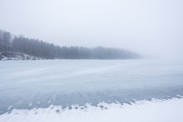 Thick fog at frozen lake landscape