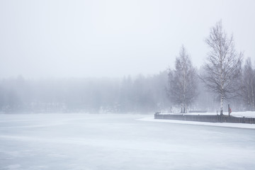 Thick fog at frozen lake landscape