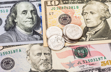 Russian rubles coins over dollars banknotes close up