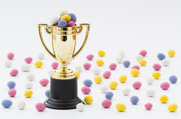 A gold trophy full of Easter eggs for the winner of an Easter egg hunt. Isolated white background...