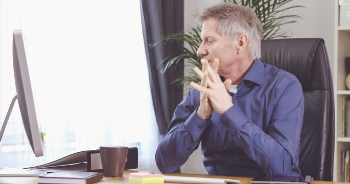 Portrait of a man with grey hair have a problem and fail at his desk in a home office