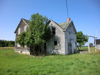 Obraz premium Abandoned weathered wooden farmhouse exterior - landscape color photo