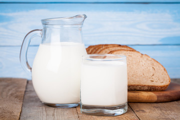 Bread slices, milk on a wooden table and blue wooden background