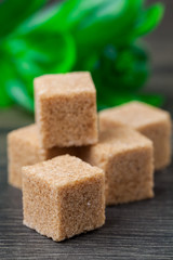 Brown lump sugar on rustic wooden board
