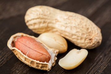 Peeled Peanut on wood background. Selective focus.