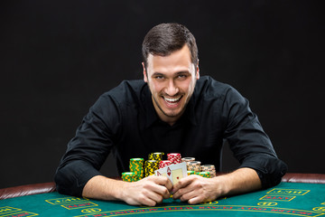 Happy poker player winning and holding a pair of aces