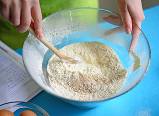 Woman hand mixing flour in bowl