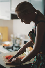 Obraz na płótnie Canvas Young woman cutting vegetables