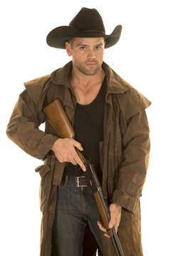 cowboy in black hat and duster hold rifle look