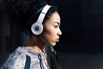 Fit and sporty young woman listening to music with mobile phone.
