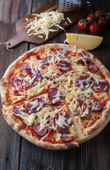 Delicious pizza with salami, tomatoes