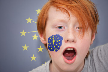 redhead fan boy with indiana state flag painted on his face. - obrazy, fototapety, plakaty