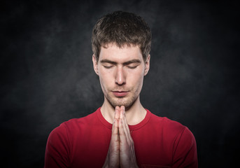 Man praying with hands clasped.