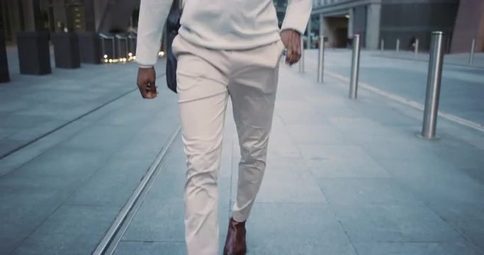 African American businessman walking through city using smart phone