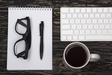 Mix of office supplies and gadgets on a wooden background.