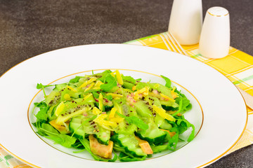 Healthy and diet food: Salad with arugula, avocado, kiwi, cucumb