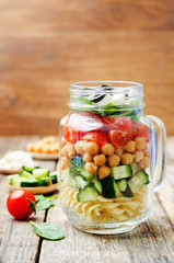 Pasta chickpeas cucumber tomatoes spinach goat cheese salad in a