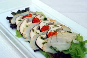 Piatto di pesce crudo con funghi.