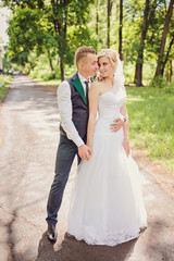 Naklejka premium Young wedding couple enjoying romantic moments outside on a summer meadow