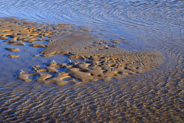 Waves of sand peninsula in the reflection, like a heart.