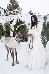 Beautiful bride in a fur cape with reindeer