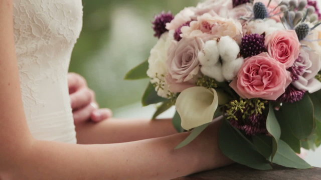 Bride and groom tenderly holding each other with bouquet in hands close up. Romantic wedding in Paris