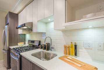 Modern, bright, clean, kitchen interior with stainless steel appliances in a luxury house