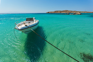 Fototapeta na wymiar Small boat in Paranga Beach on the island of Mykonos, Cyclades, Greece