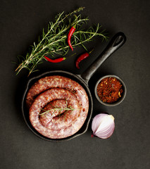 raw beef sausages on a cast-iron pan,  selective focus