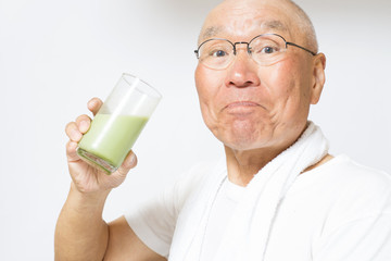 健康ドリンクを笑顔で飲むシニア