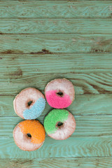 Sweet and vibrant donuts on wooden table,