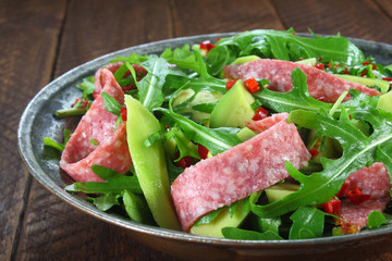 Salad with arugula, salami and avocado