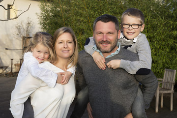 Parents giving piggyback ride to children