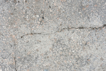 Rough concrete floor with cracks and small stones background texture