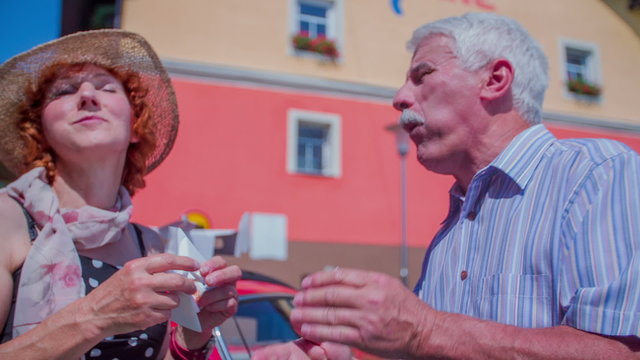 A Senior Couple Eating Their Last Bite Of The Doughnuts