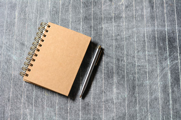 Notebook and pen on the wooden floor.