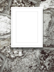 Close-up of one white picture frame on grey ancient stone wall background