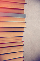 Stack of books on light wall background, close up