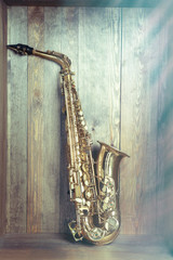 Golden saxophone on wooden background