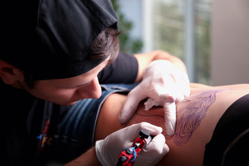 Tattooist makes tattoo, close up