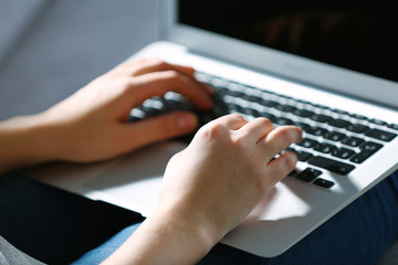 Woman sitting on sofa with a laptop in a room