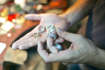 Man handling the handmade rings at jewelry workshop