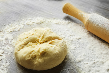 Fresh prepared dough on a wooden board, close up