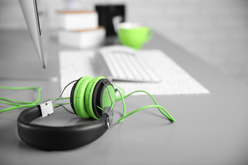 Fototapeta na wymiar Headphones on gray table against defocused background