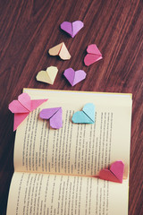 Heart bookmarks for book on wooden background