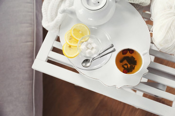 White tea set on a wooden tray on table